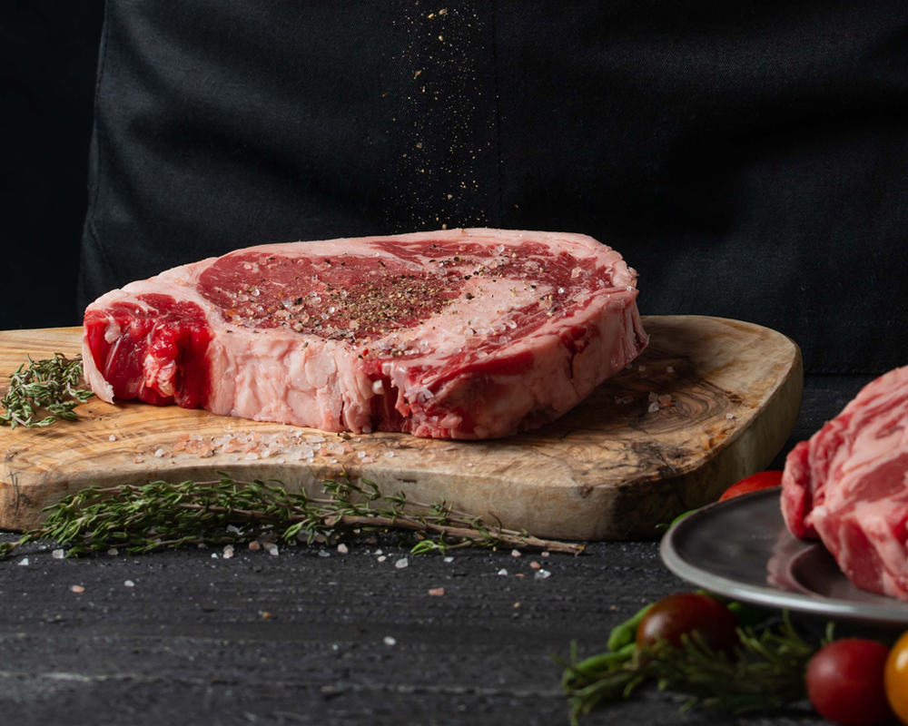 Steak auf Schneidebrett marinieren