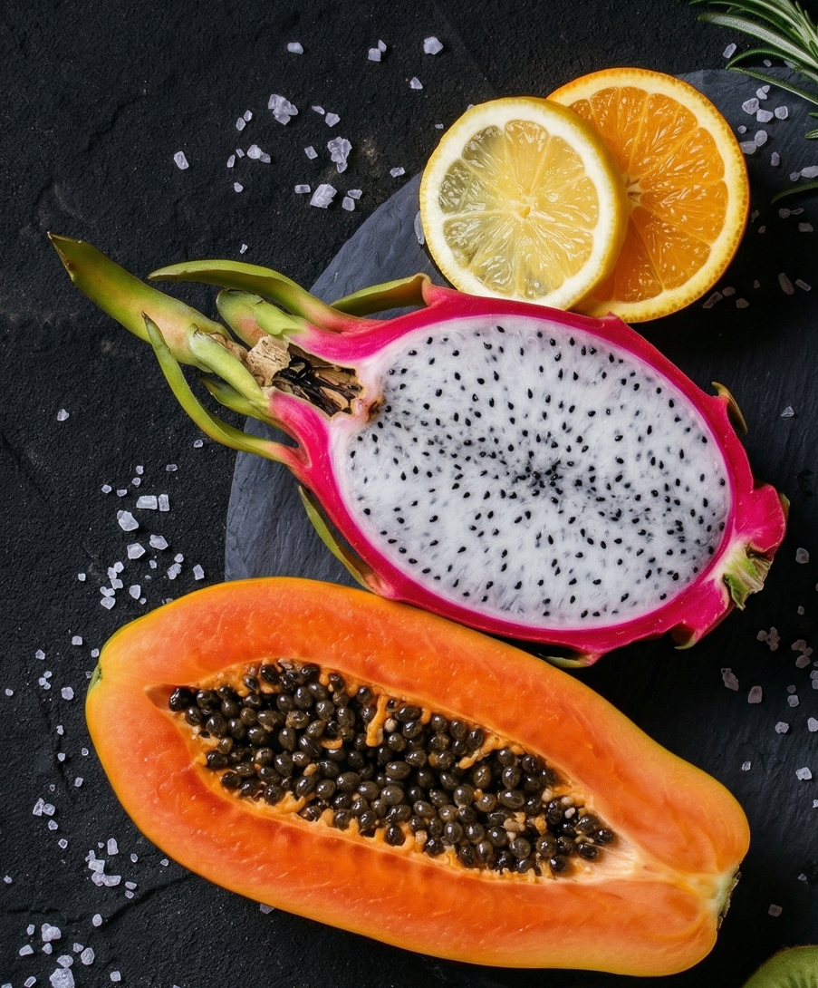 Papaya, Drachenfrucht, Kiwi und Passionsfrucht  auf einer Steinplatte serviert