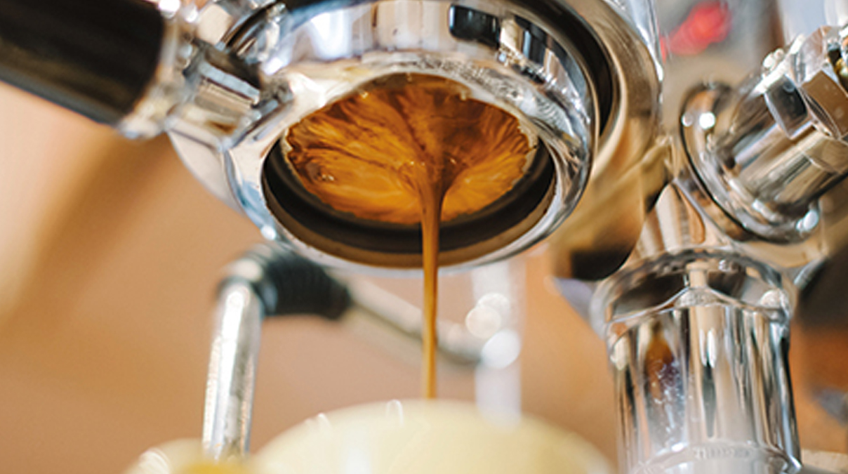 Kaffee läuft aus Kaffeemaschine in Tasse